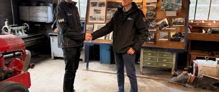 Official image supplied by HamiltonJet — official photograph of Mike Hamilton congratulating Sam Hamilton in the original Irishman Creek workshop.